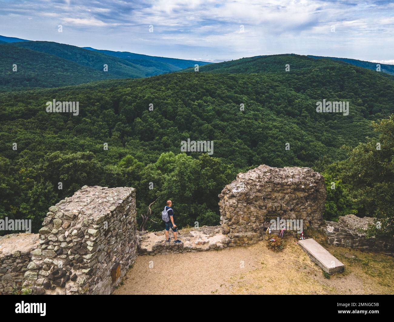 Ein Mann steht an der Burgmauer und blickt auf die umliegende Landschaft, Drégelypalánk, Ungarn Stockfoto
