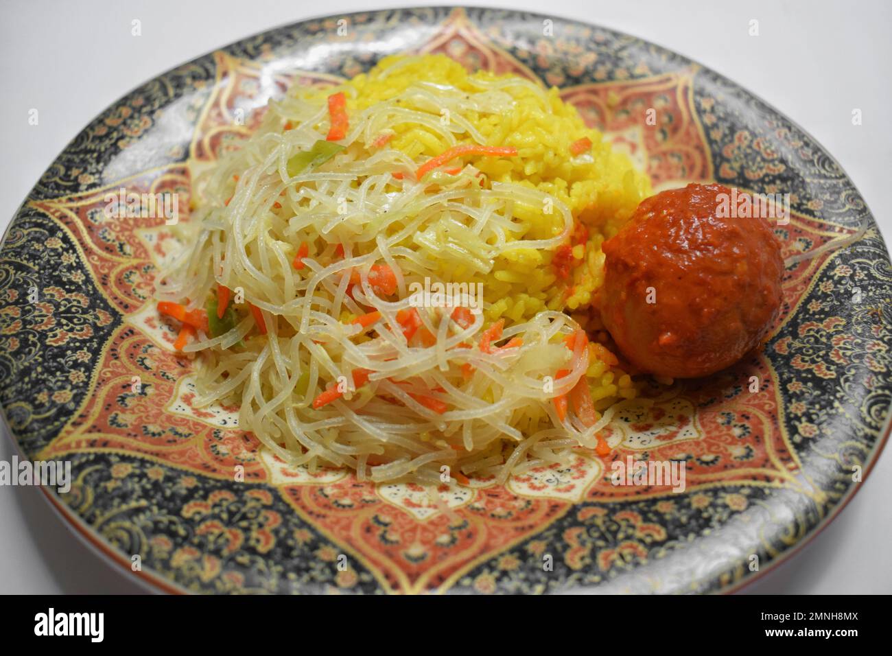 Dies ist traditionelles indonesisches Essen, gelber Reis, mit Zusatz von Nudeln und roten Sauce Eiern Stockfoto