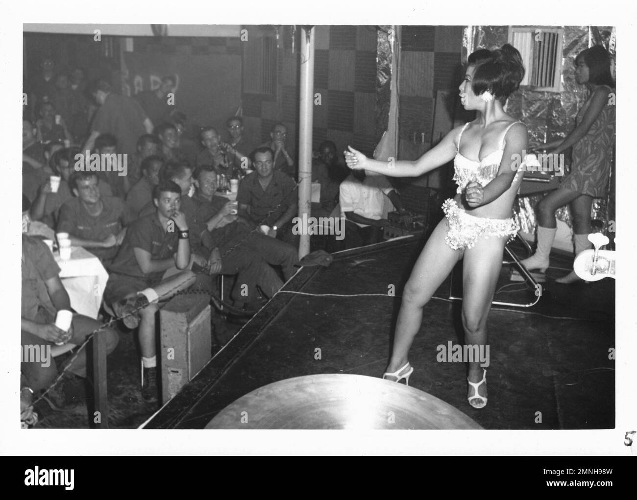 [Naval Support Activity Hospital Danang, Vietnam]. 71. Geburtstagsparty des Krankenhauskorps am 16. Juni 1969. Frau, die im Bikini tanzt, um die Truppen während des Vietnamkriegs zu unterhalten. Stockfoto