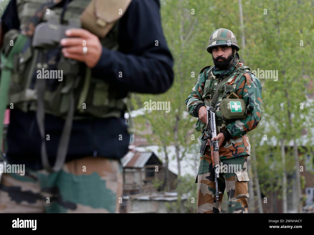 Indian army soldiers stands guard during a gun battle in Khudwani village about 60 kilometers (37 miles) south of Srinagar, Indian controlled Kashmir, Wednesday, April. 11, 2018. Three men were killed in Kashmir when government forces fired on anti-India protesters who thronged a village following a gun-battle that killed three rebels and a soldier, officials said Wednesday. (AP Photo/Mukhtar Khan) Stockfoto