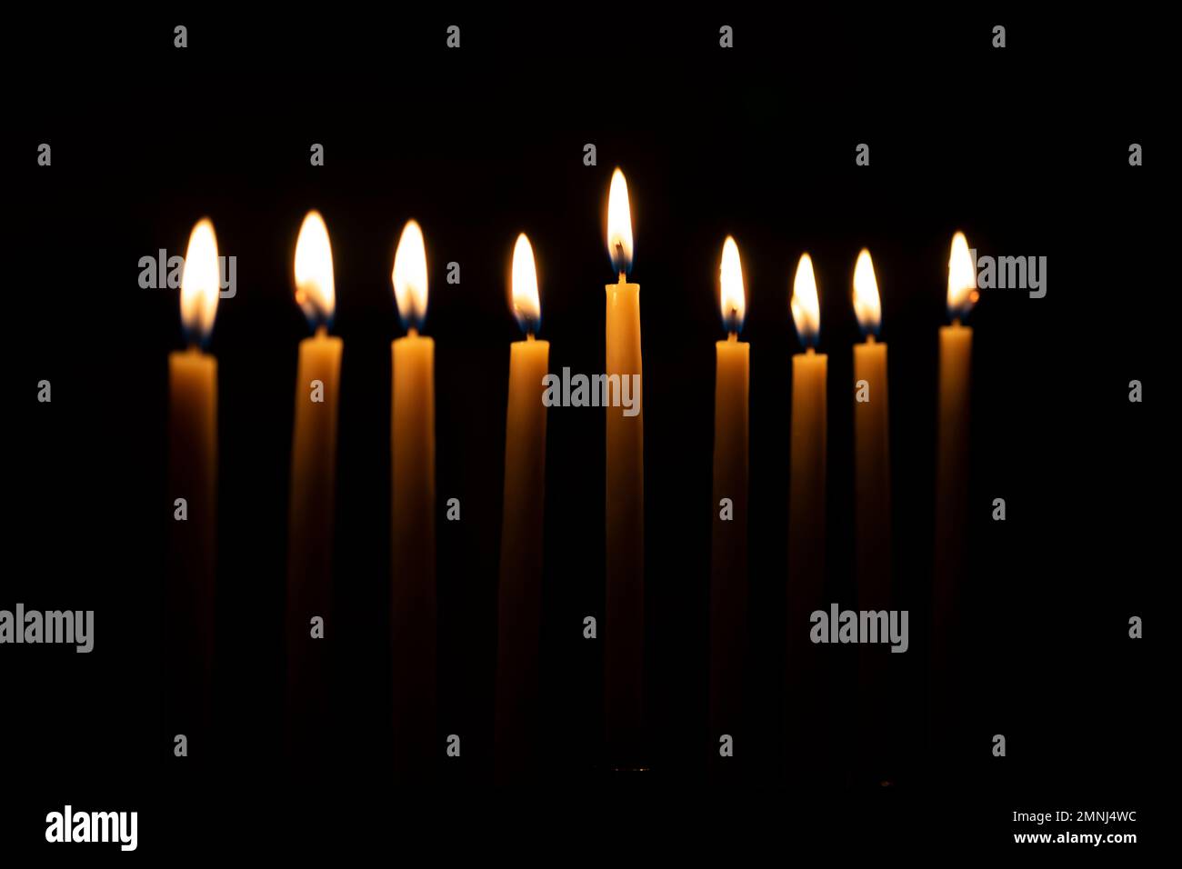 Kerzenreihe vor schwarzem Hintergrund Stockfoto