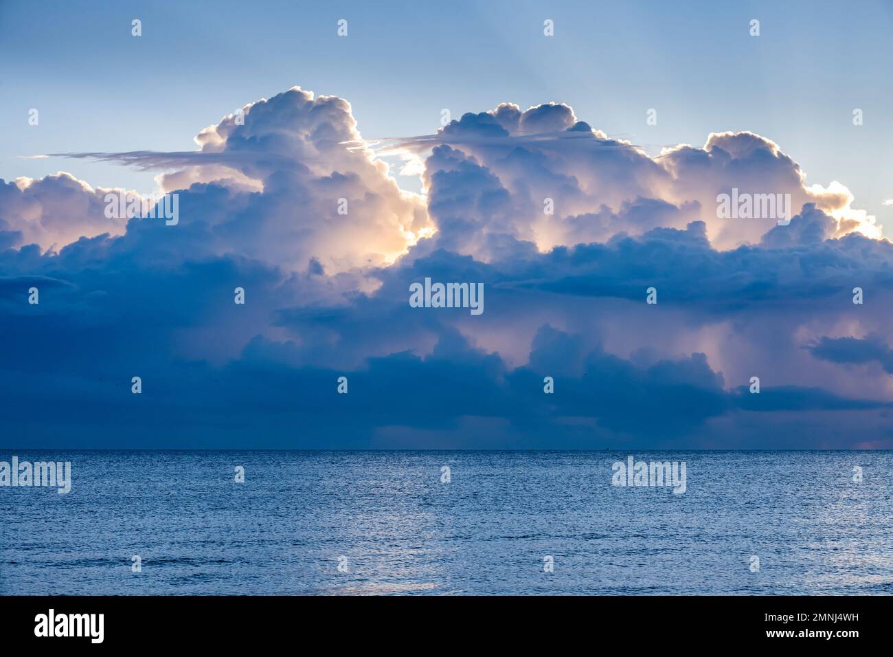 Wolken über dem ruhigen Ozean bei Sonnenaufgang Stockfoto Wolken über dem ruhigen Ozean bei Sonnenaufgang Stockfoto