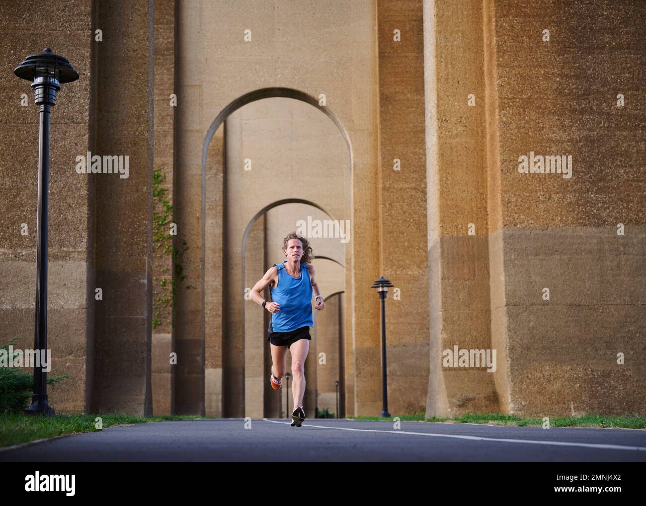 Ein Mann joggt unter der Brücke Stockfoto