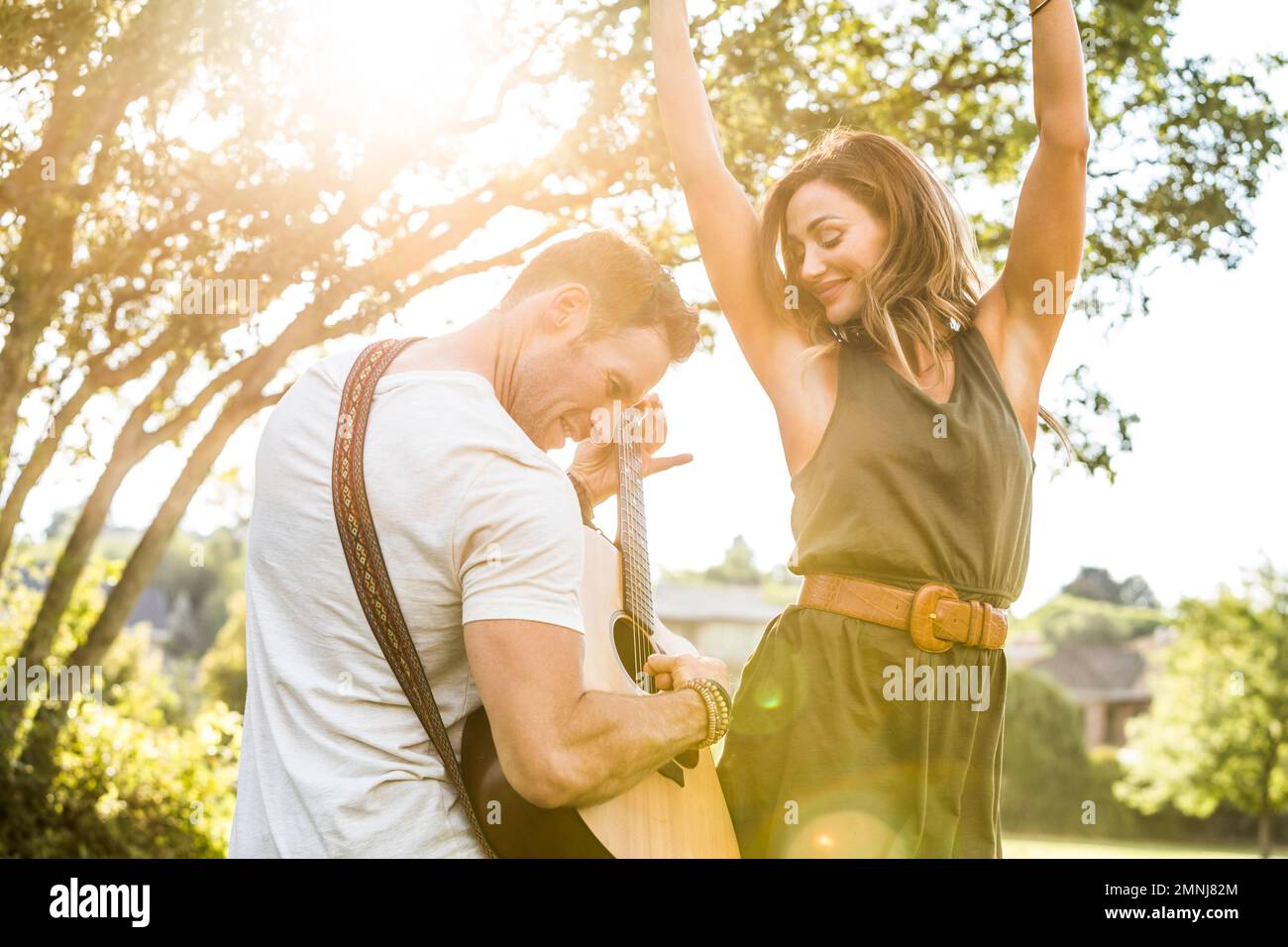 Romantisches Paar, das Gitarre spielt und tanzt Stockfoto