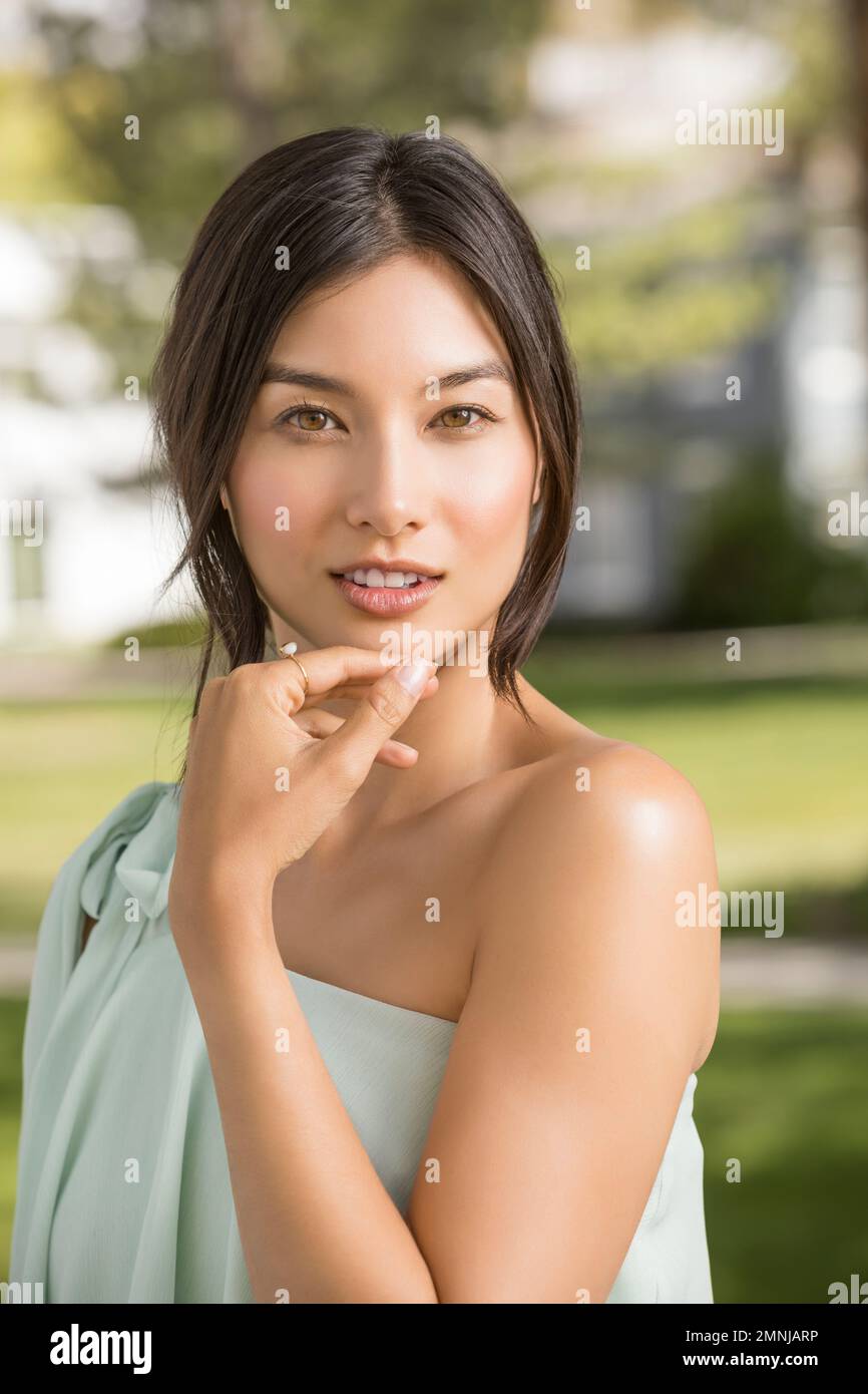 Porträt einer schönen Frau, die im Park in die Kamera schaut Stockfoto