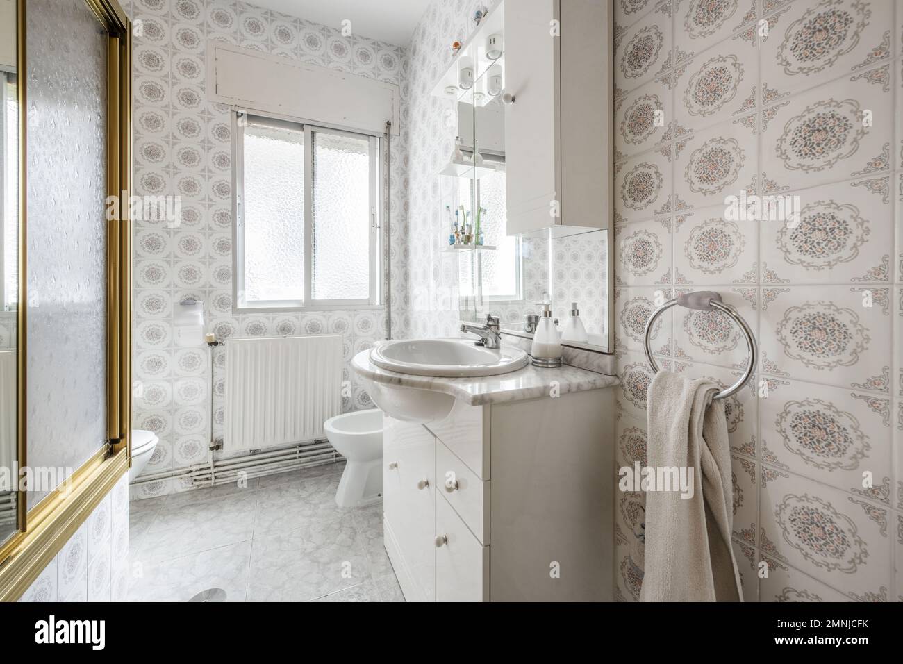 Toilette mit weißem Holzschrank mit Marmorplatte und Spiegel mit Schubladen und integrierten Lampen Stockfoto