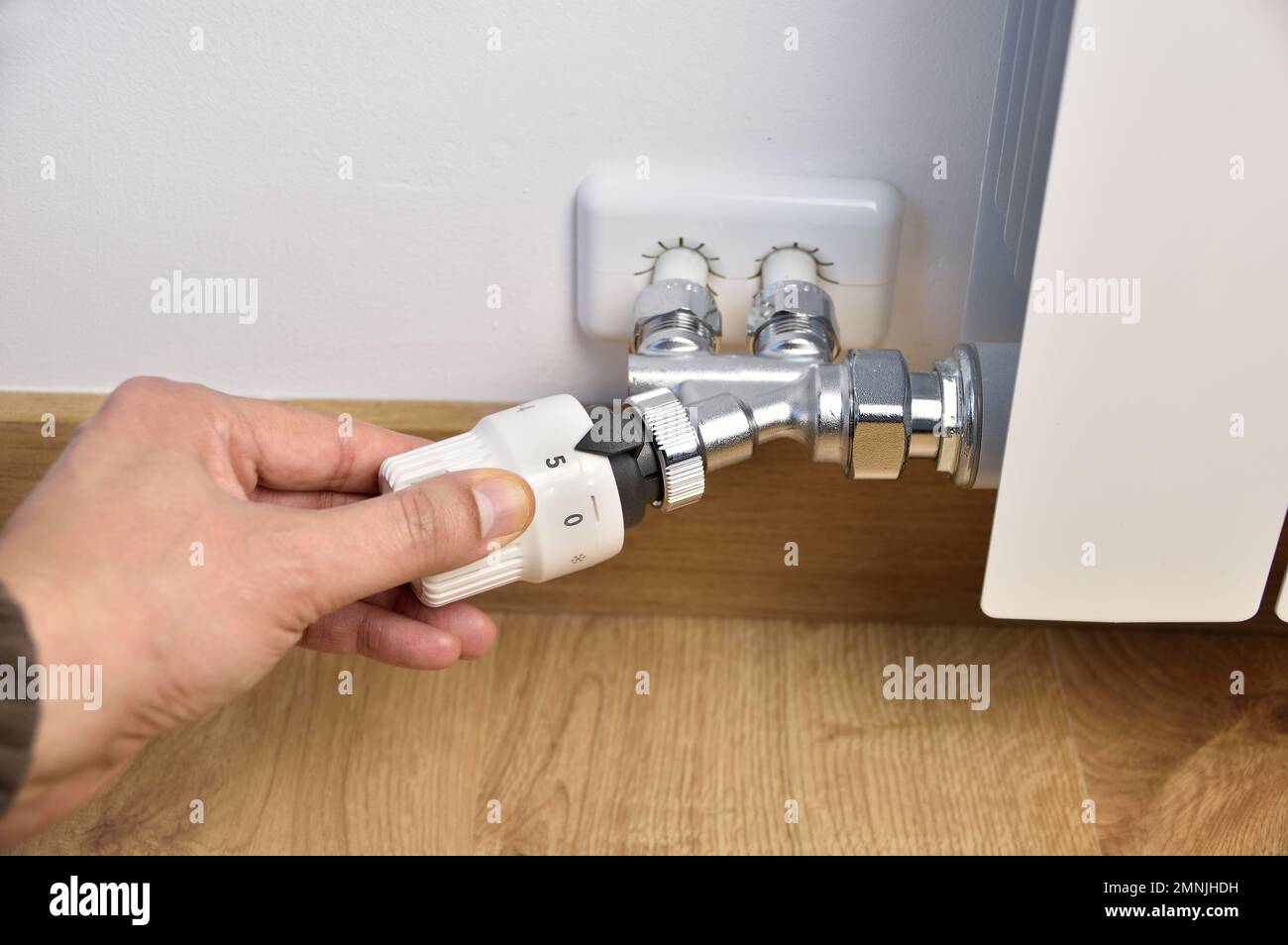 Das Thermostatventil lässt sich zu Hause mit einer Hand schließen Stockfoto