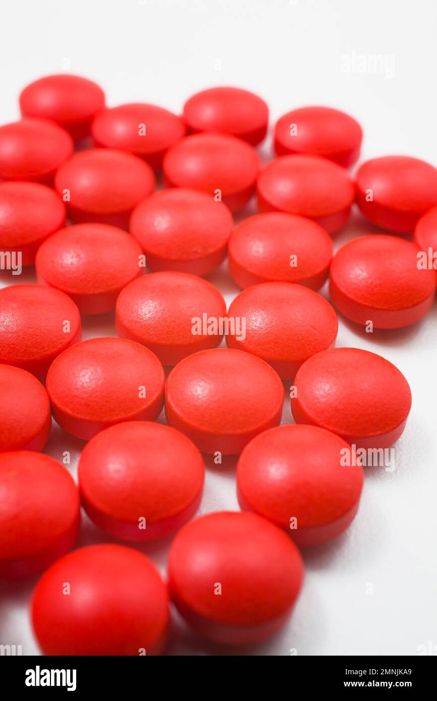 Rote Arzneimittelpillen auf weißem Hintergrund. Stockfoto