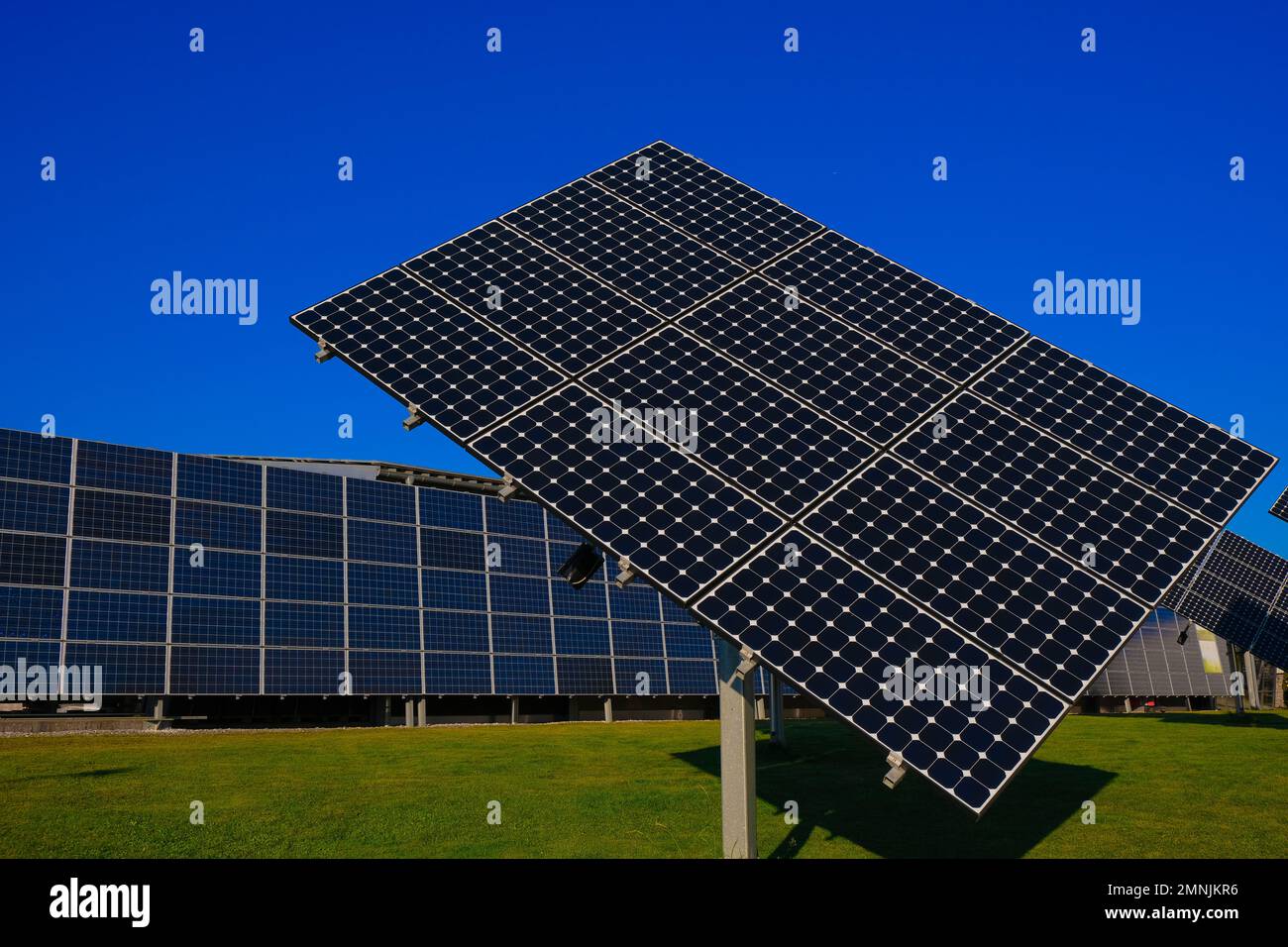 Erneuerbare, saubere Energie aus Sonnenlicht. Sonnenkollektoren mit leuchtend blauem Hintergrund. Sonnenkollektoren auf der Straße. Stockfoto