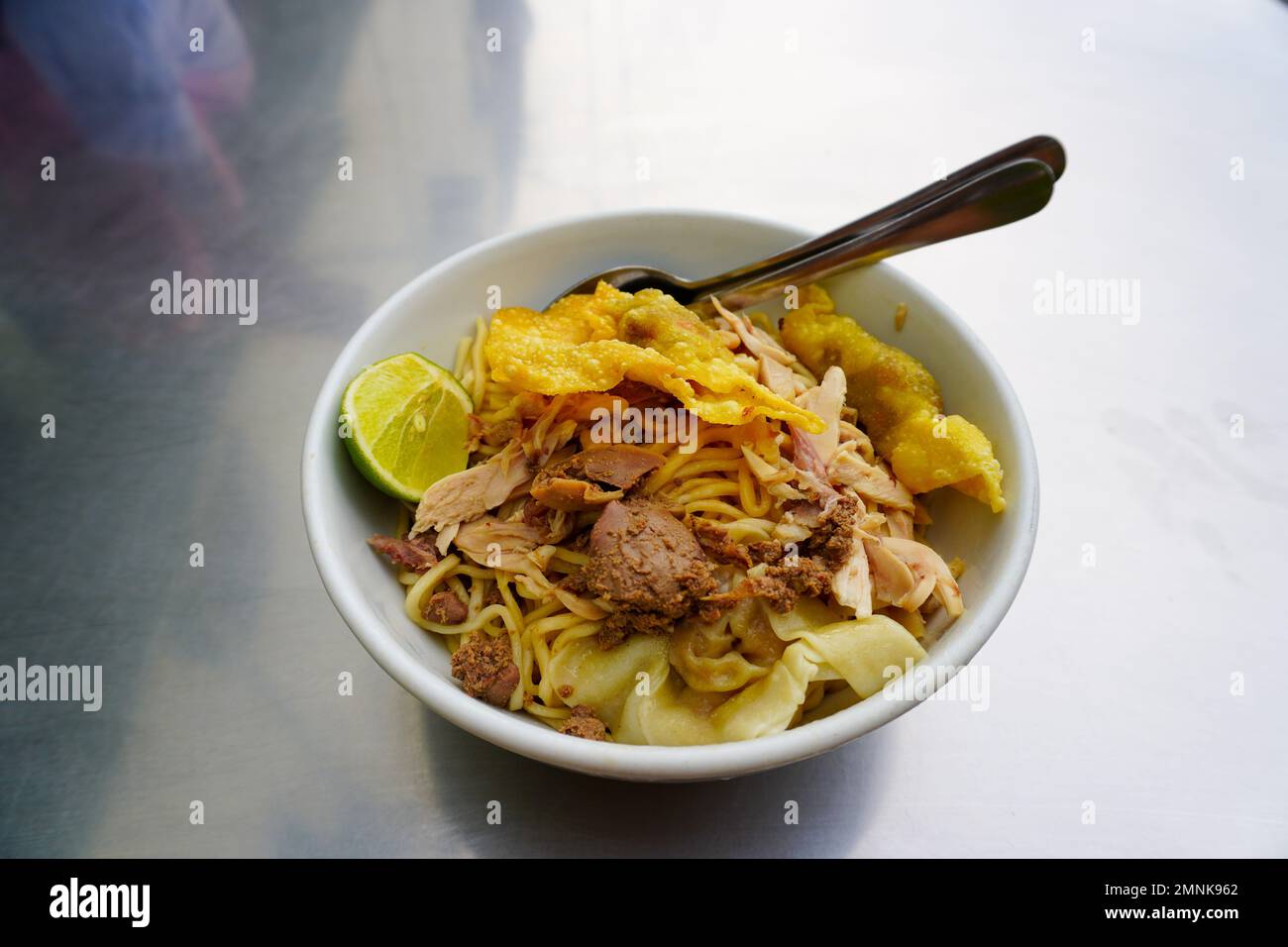 Mie Ayam. Indonesisches lokales Essen Hühnchen Nudeln und Soße in separaten Schalen Stockfoto