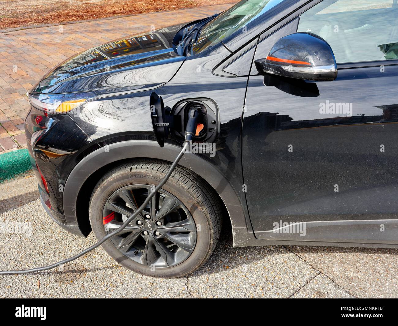 Chevy Bolt EUV, Elektroauto oder Automobil, angeschlossen an eine Straßenladestation zum Aufladen am Straßenrand, in Montgomery Alabama, USA. Stockfoto