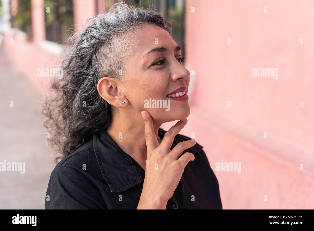 Reife Frau mit grauem Haar, die draußen posiert Stockfoto