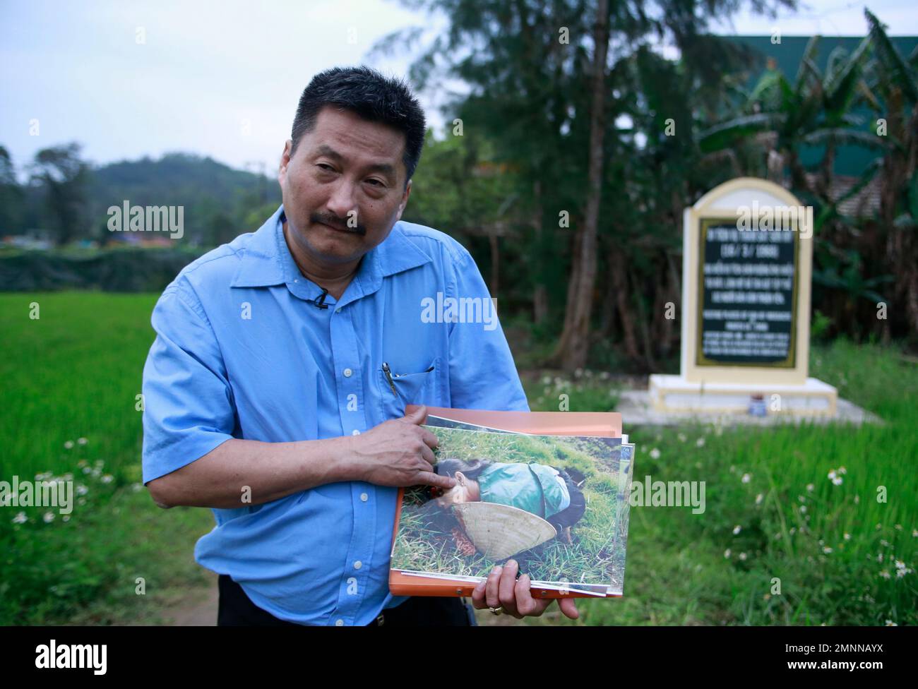 In this Mar. 15, 2018, photo, My Lai massacre survivor Tran Van Duc points at a photo taken by U.S. army photographer Ron Haeberle of his mother Nguyen Thi Tau, who was killed in the massacre in My Lai, Vietnam. More than a thousand people attend the commemoration marking the 50th anniversary of the My Lai massacre in which 504 unarmed civilians, most of the children, women and elderly men. (AP Photo/ Hau Dinh) Stockfoto