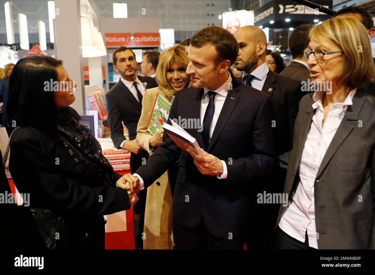 French President Emmanuel Macron, his wife Brigitte Macron (rear) and French Culture Minister Francoise Nyssen, right, attend the inauguration of the Paris Book Fair in Paris, Thursday, March 15 2018. The Paris Book Fair runs until March 19. (Etienne Laurent, Pool via AP) Stockfoto