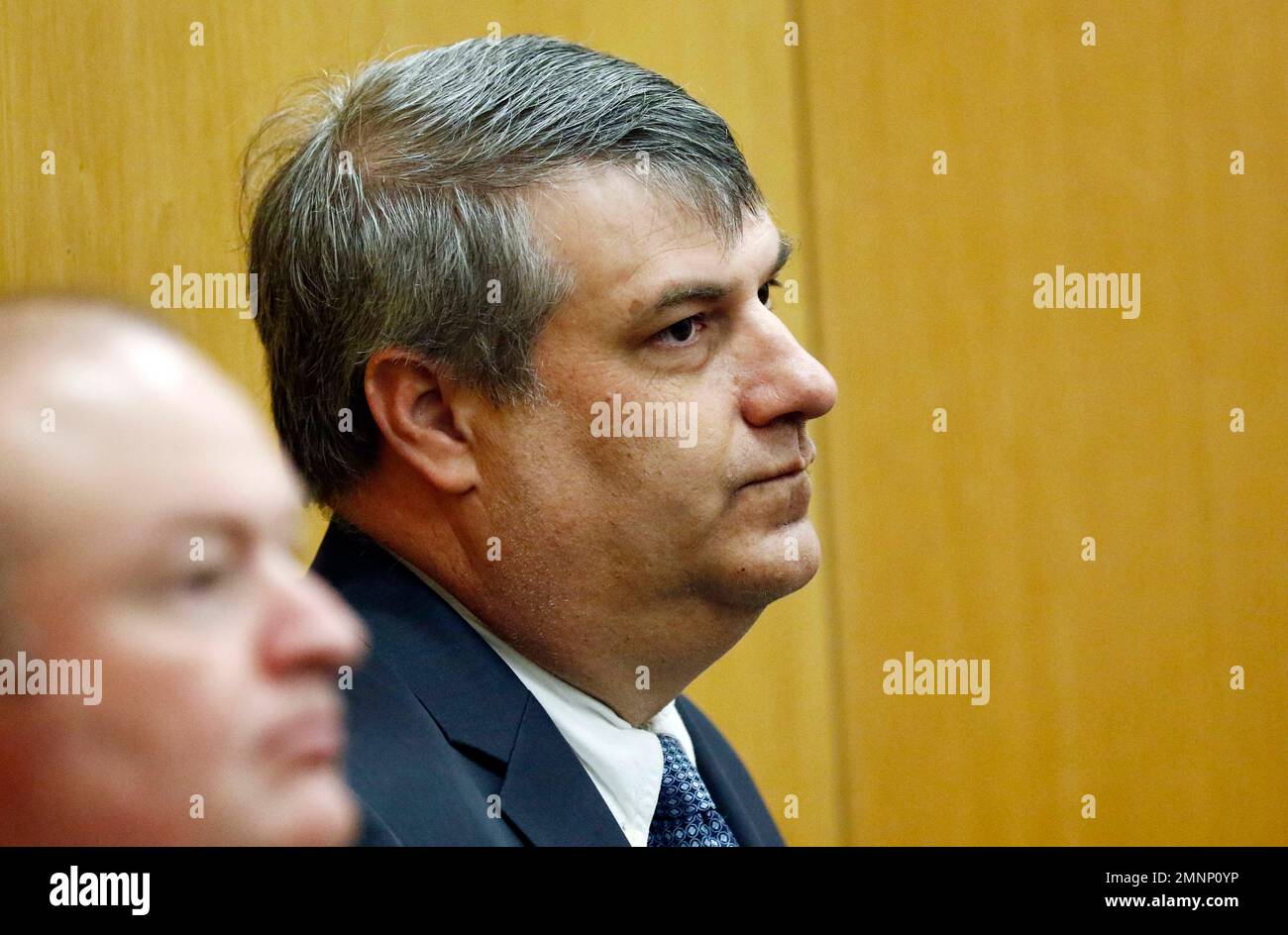 District Attorney Dee Bates, right, listens as the charges are read in