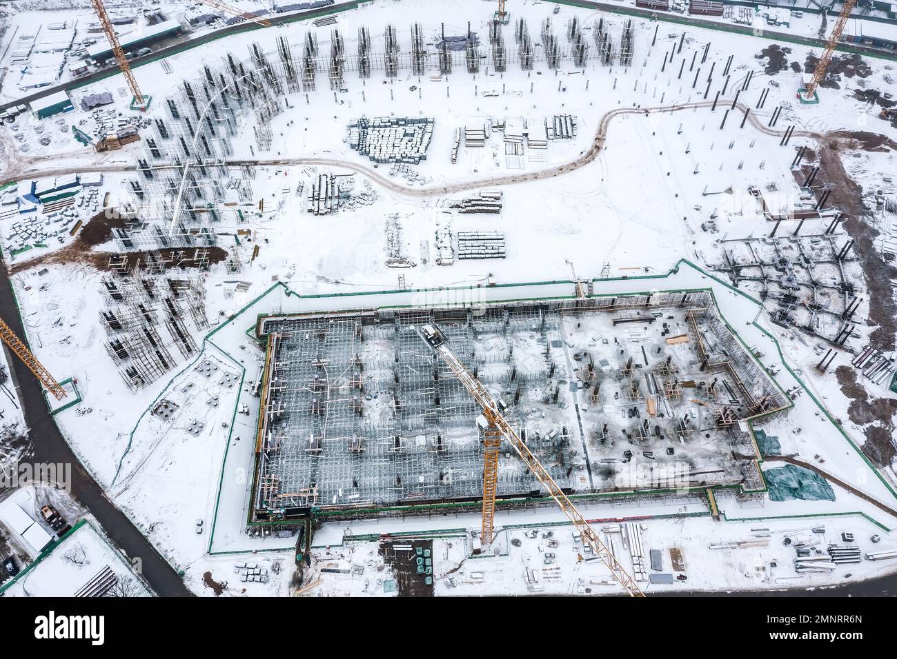 Bau eines neuen Fußballstadions im Winter. Grundlagenarbeit. Säulen aus verstärktem Stahl. Drohnenfoto. Stockfoto