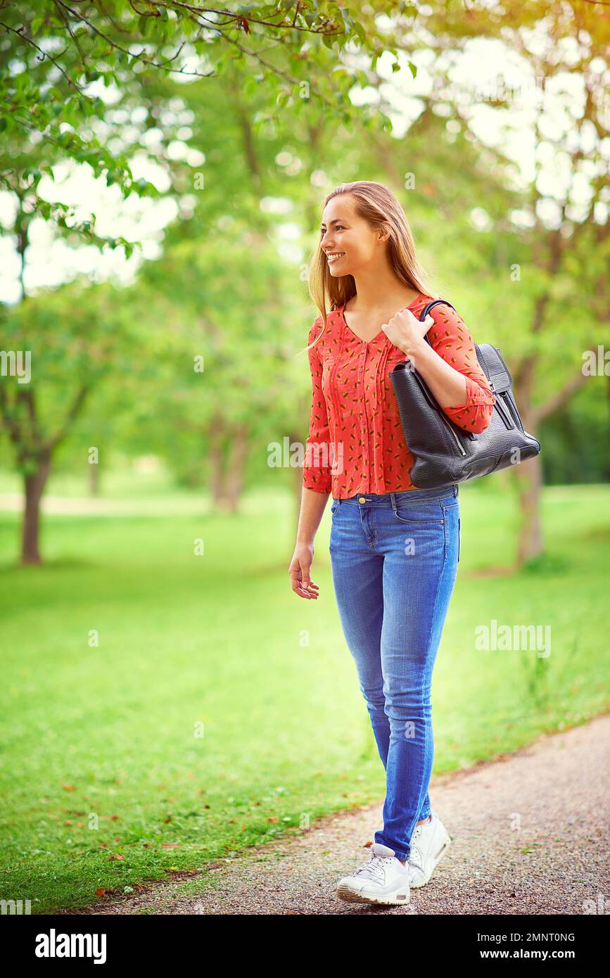 Das Leben zu schätzen, ist einfach nur Vergnügen. Eine junge Frau auf einem Spaziergang durch den Park. Stockfoto