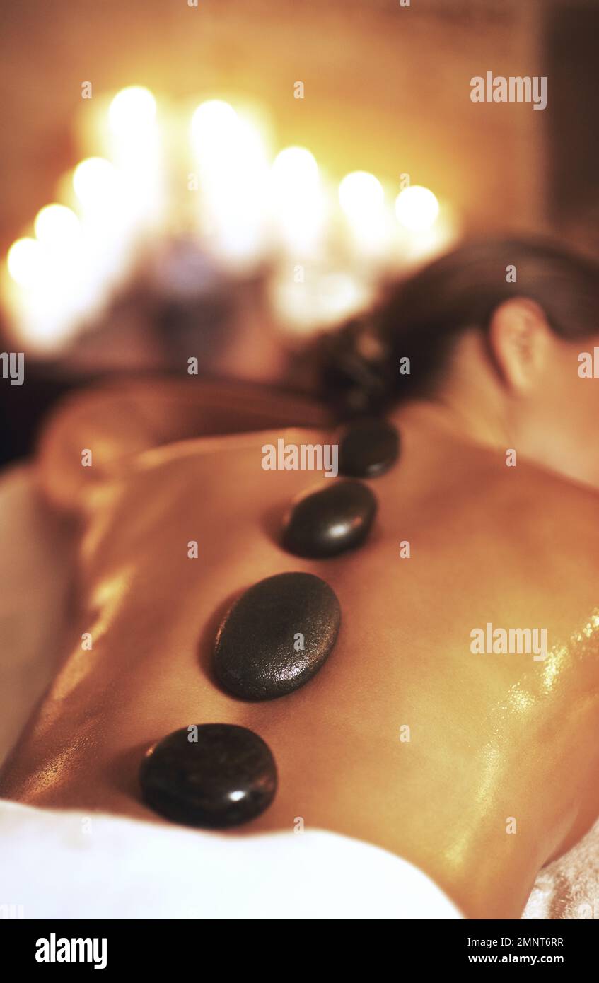 Alternative Medizin ist das Originalarzneimittel. Eine junge Frau, die eine Hot-Stone-Massage bekommt. Stockfoto