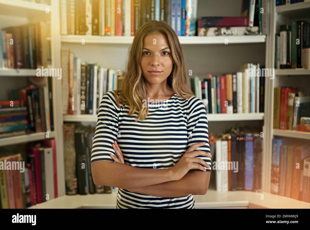 Mein Geschäft floriert. Porträt einer Frau, die in ihrem Heimbüro vor Bücherregalen steht. Stockfoto