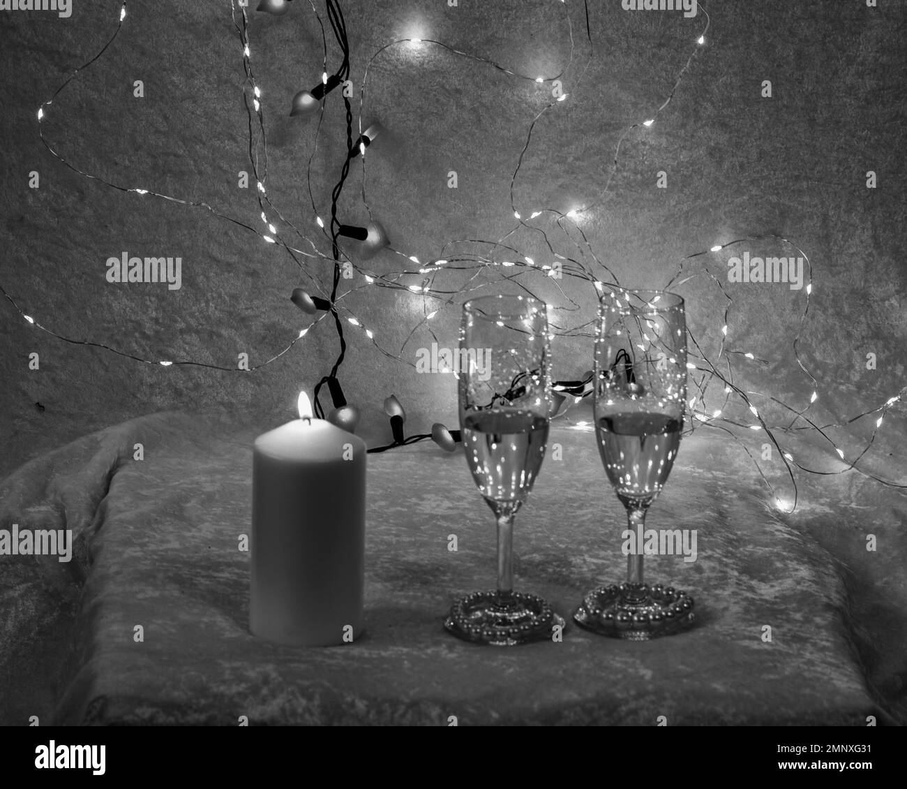 Schwarz-Weiß-Stille mit zwei Champagnergläsern, verschwommenen Spots im Hintergrund, Urlaubskonzept, Freiraum für Text, glücklicher Valentinstag Stockfoto