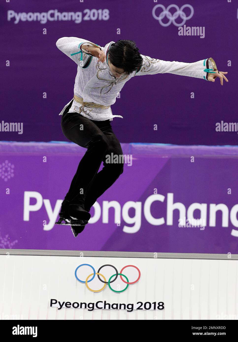 Yuzuru Hanyu of Japan leaps onto the podium as he celebrates his gold medal win in the the men's free figure skating final in the Gangneung Ice Arena at the 2018 Winter Olympics in Gangneung, South Korea, Saturday, Feb. 17, 2018. (AP Photo/David J. Phillip) Stockfoto