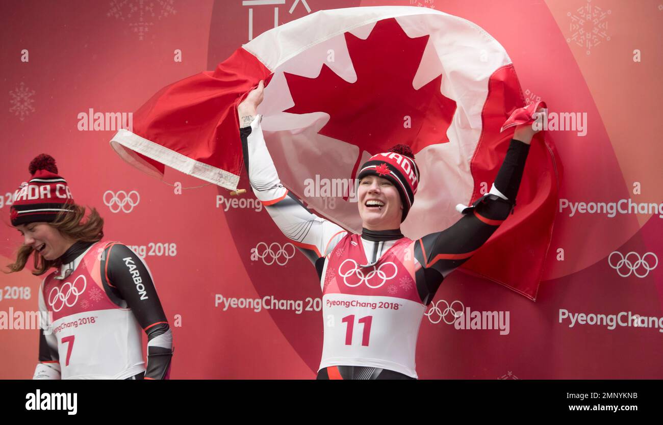 Canadian luger Alex Gough, of Calgary celebrates winning a bronze medal in women's luge as Kim McRae, of Calgary looks on at the Olympic Siding Centre at he Pyeongchang 2018 Winter Olympic Games in South Korea, Tuesday, Feb. 13, 2018. (Jonathan Hayward/The Canadian Press via AP) Stockfoto