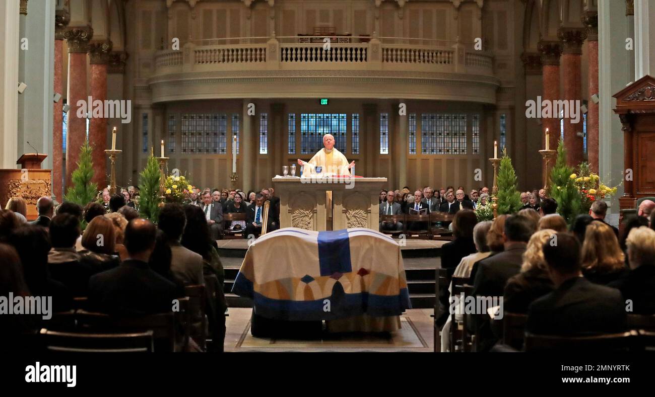 The Rev. Oliver Duggan prepares communion during a joint funeral Mass for former Gov. John Spellman and that of his wife, Lois Spellman, their caskets covered in a dual white pall, at St. James Cathedral Monday, Feb. 12, 2018, in Seattle. John Spellman, the last Republican to serve as Washington's chief executive, died last month at the age of 91. Lois Spellman, his wife of 63 years, died days later. (AP Photo/Elaine Thompson) Stockfoto