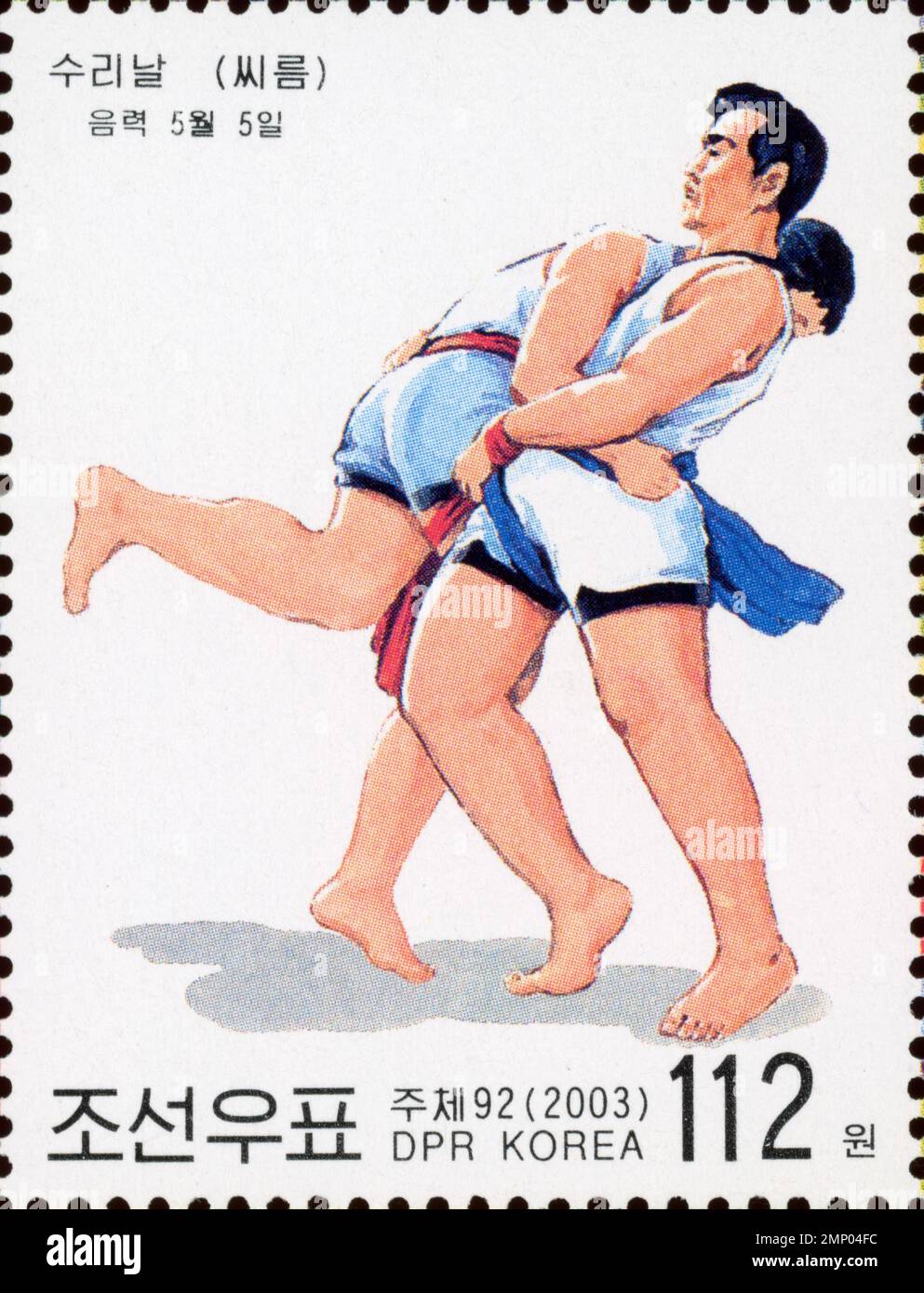 2003 Nordkoreas Briefmarke, die das traditionelle Ssireum-Ringen für das Surinal-Festival zeigt und zwei Athleten in einem Match zeigt. Stockfoto