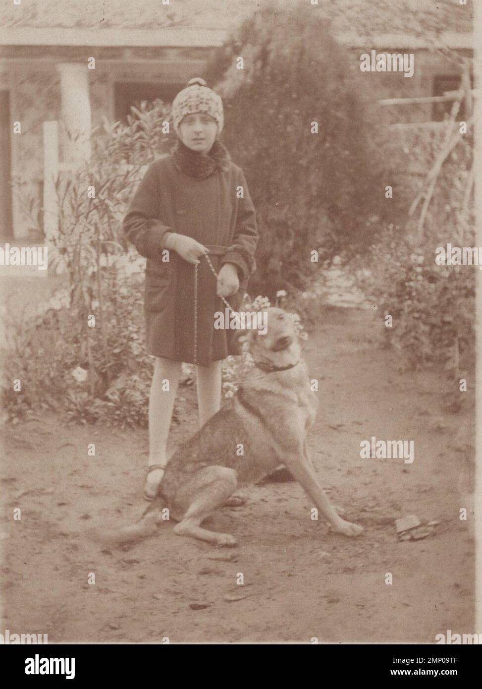 Vintage Moment / Vintage lustiger Moment / Vintage Foto / Power of the Moment / magische Momente / junge Dame mit ihrem netten großen deutschen Sheperd Hund vor ihrem Garten im 1920er Stockfoto