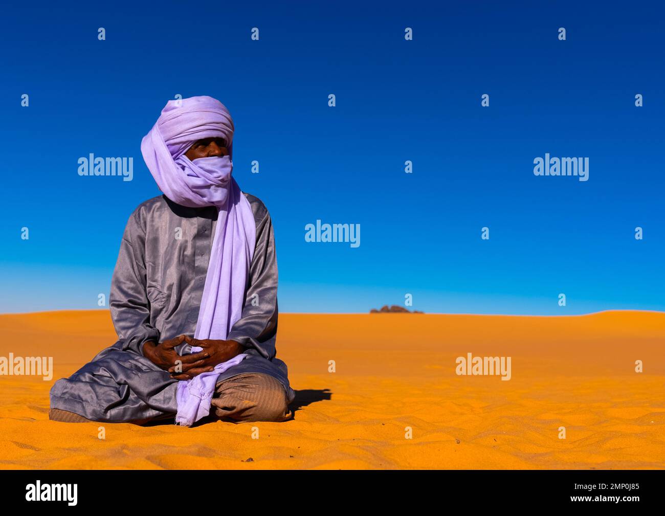 Tuareg sitzt in der Sahara-Wüste, Nordafrika, Erg Admer, Algerien Stockfoto