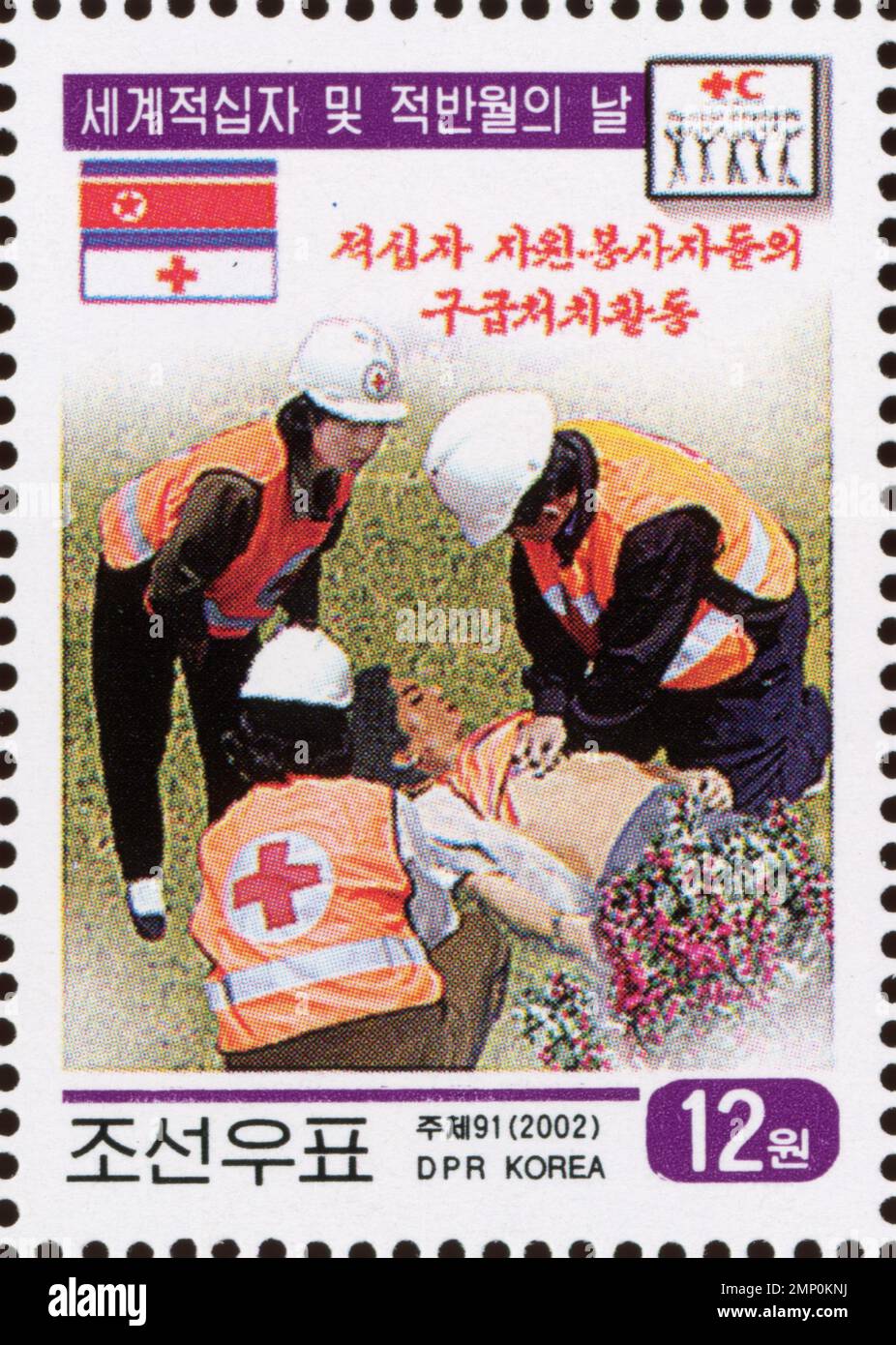 Nordkoreanische Briefmarke aus dem Jahr 2002, die Freiwillige des Roten Kreuzes zeigt, die erste Hilfe für den Welt-Roten Kreuz und den Roten Halbmond leisten. Stockfoto