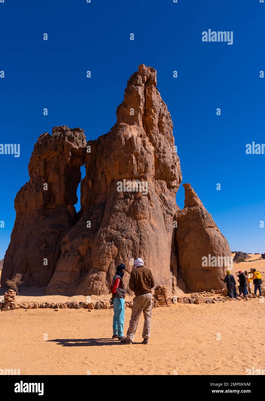 Touristen, die die Felsschnitzerei La Vache qui pleure, Nordafrika, Erg Admer, Algerien besuchen Stockfoto