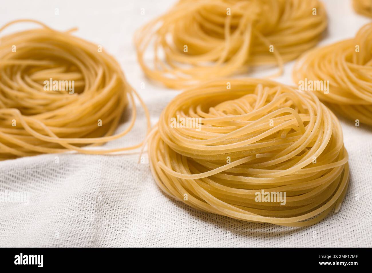 Capellini-Pasta auf weißer Tischdecke, Nahaufnahme Stockfoto