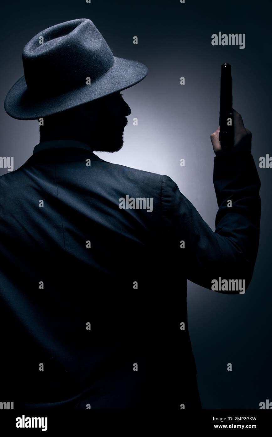 Gangster, Silhouetten oder Waffenbesitzer im Studio in geheimer Spionage, isolierter Mafia-Führung oder Kriminalitätssicherheit. Model, Mann oder dunkler Killer und Stockfoto