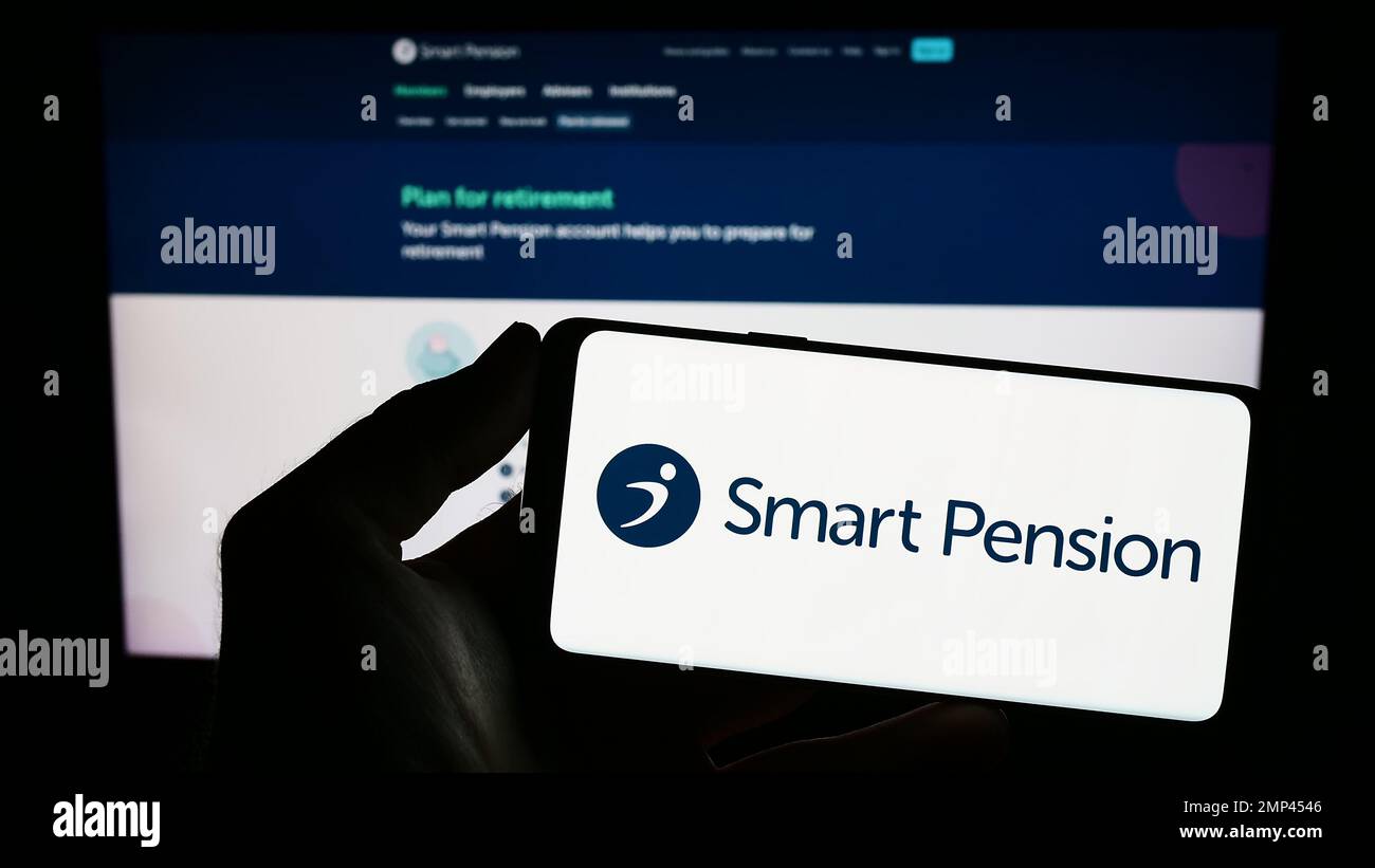 Person, die ein Mobiltelefon mit dem Logo des britischen Fintech-Unternehmens Smart Pension Limited auf dem Bildschirm vor der Webseite hält. Konzentrieren Sie sich auf das Display des Telefons. Stockfoto Person, die ein Mobiltelefon mit dem Logo des britischen Fintech-Unternehmens Smart Pension Limited auf dem Bildschirm vor der Webseite hält. Konzentrieren Sie sich auf das Display des Telefons. Stockfoto