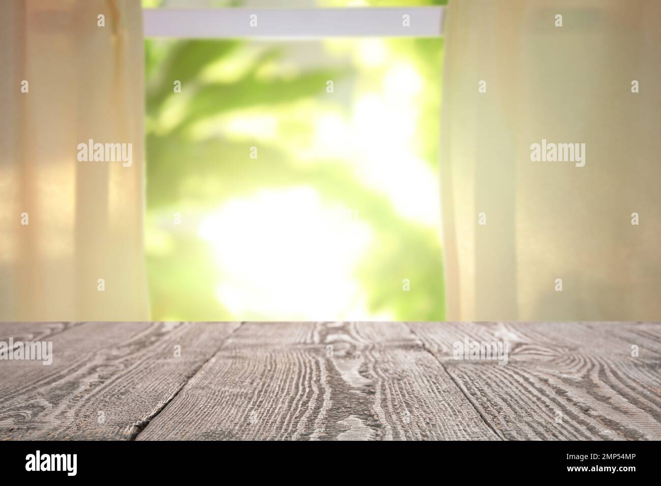 Leerer Holztisch vor dem Fenster. Sonniger Morgen Stockfoto