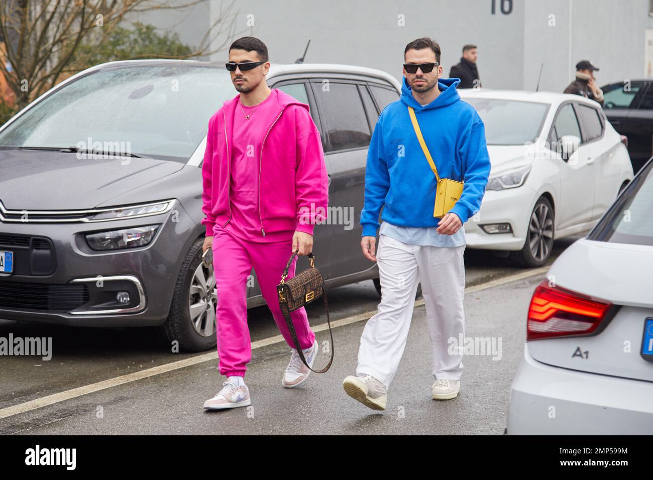 MAILAND, ITALIEN - 15. JANUAR 2023: Männer mit pinkfarbenem Sweatsuit und blauem Hoodie vor der Etro-Modenschau, Mailand Fashion Week Street Style Stockfoto