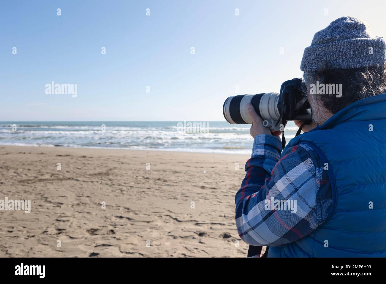 Outdoor-Fotograf mit großem Digitalzoom als professionelle Ausrüstung, die sich auf die Aufnahme eines Fotos vorbereitet Stockfoto