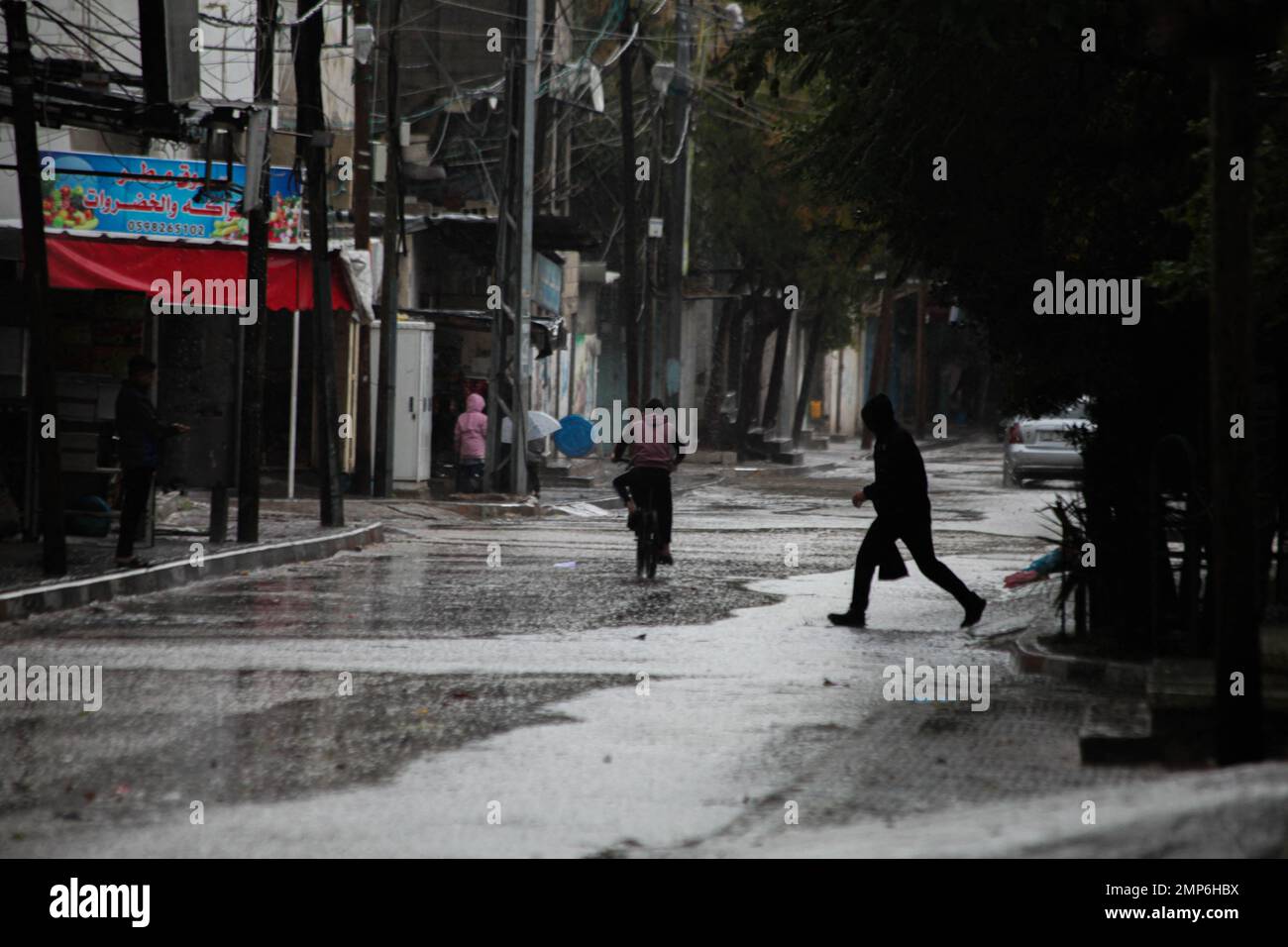 Die Palästinenser laufen am 31. Januar 2023 in Beit Lahia im nördlichen Gazastreifen in einer von Regenwasser überfluteten Straße. Das Wetter ist heute in Palästina kalt mit einem Temperaturabfall, da der niedrige Druck das Land weiterhin beeinflusst und Regen, Gewitter und gelegentliches Hagel nach Angaben der Palästinensischen Behörde für Meteorologie (PMD) bringt. Foto: Habboub Ramez/ABACAPRESS.COM Stockfoto