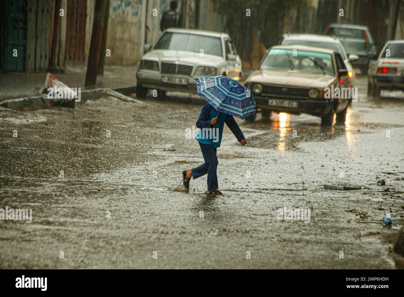Die Palästinenser laufen am 31. Januar 2023 in Beit Lahia im nördlichen Gazastreifen in einer von Regenwasser überfluteten Straße. Das Wetter ist heute in Palästina kalt mit einem Temperaturabfall, da der niedrige Druck das Land weiterhin beeinflusst und Regen, Gewitter und gelegentliches Hagel nach Angaben der Palästinensischen Behörde für Meteorologie (PMD) bringt. Foto: Habboub Ramez/ABACAPRESS.COM Stockfoto