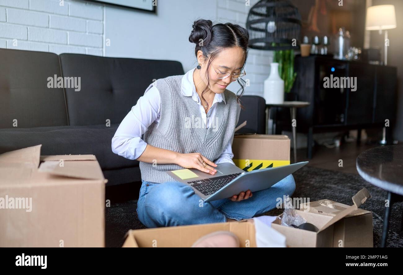 Planung, Immobilien und Frau mit einem Laptop, während sie umziehen, um eine Wohnung per E-Mail oder einen Online-Vertrag zu erhalten. Hypotheken, Kisten und asiatische Mädchen, die A schreiben Stockfoto
