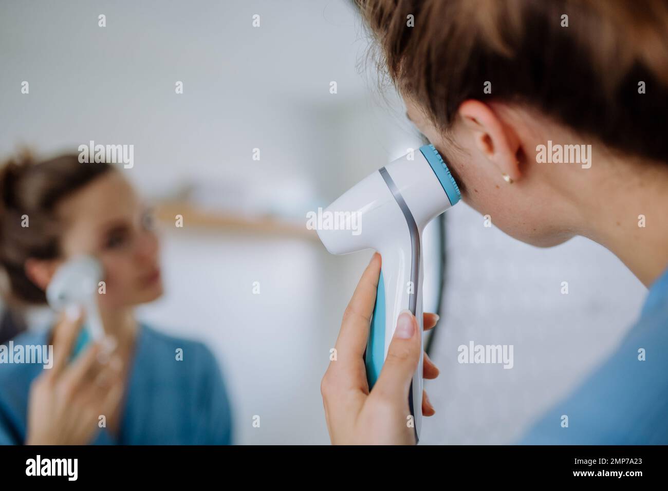 Junge Frau, die sich um ihre Haut kümmert, Morgenkosmetik-Routine-Konzept. Stockfoto