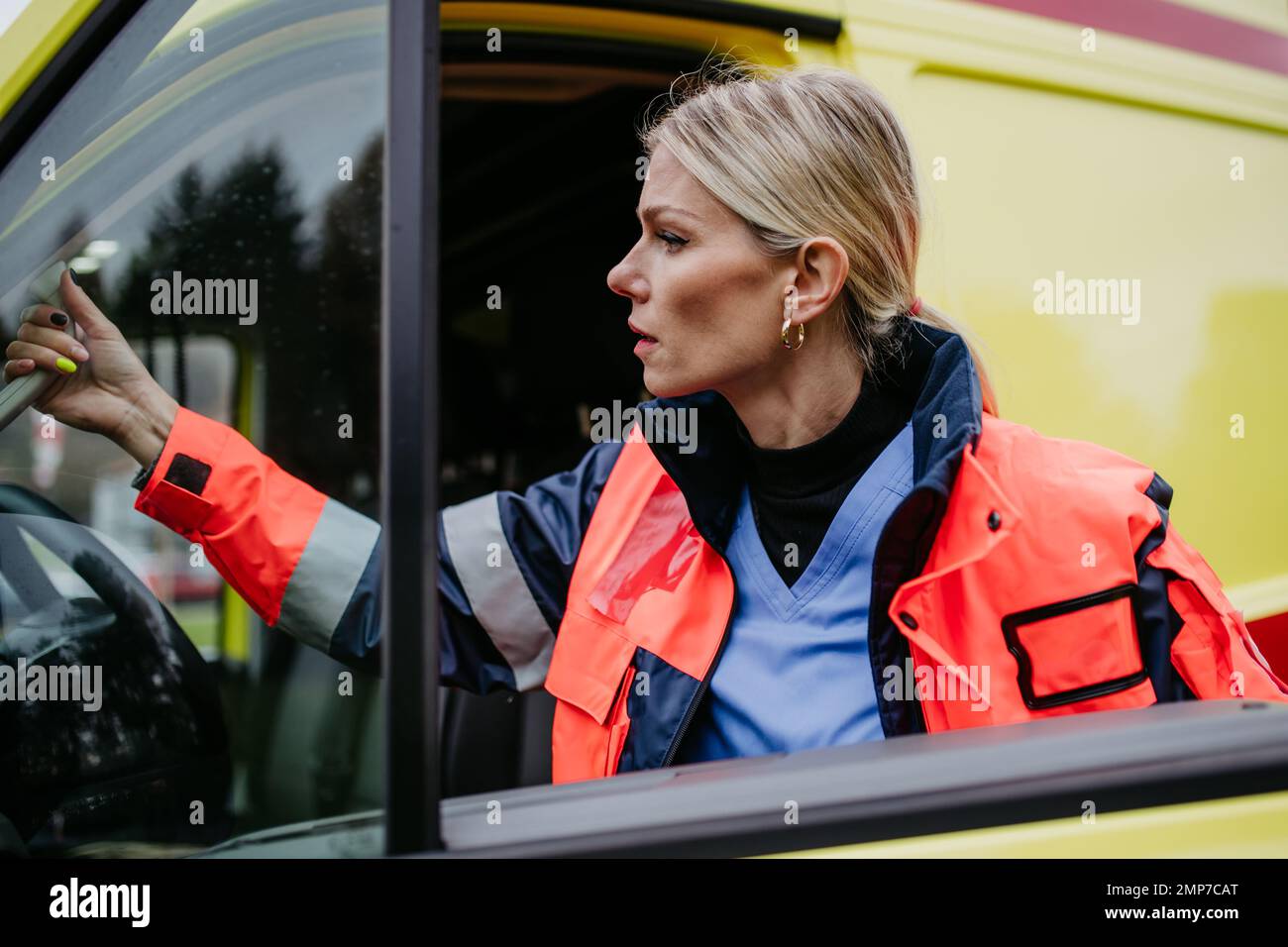 Junge Ärztin, die in den Krankenwagen steigt. Stockfoto