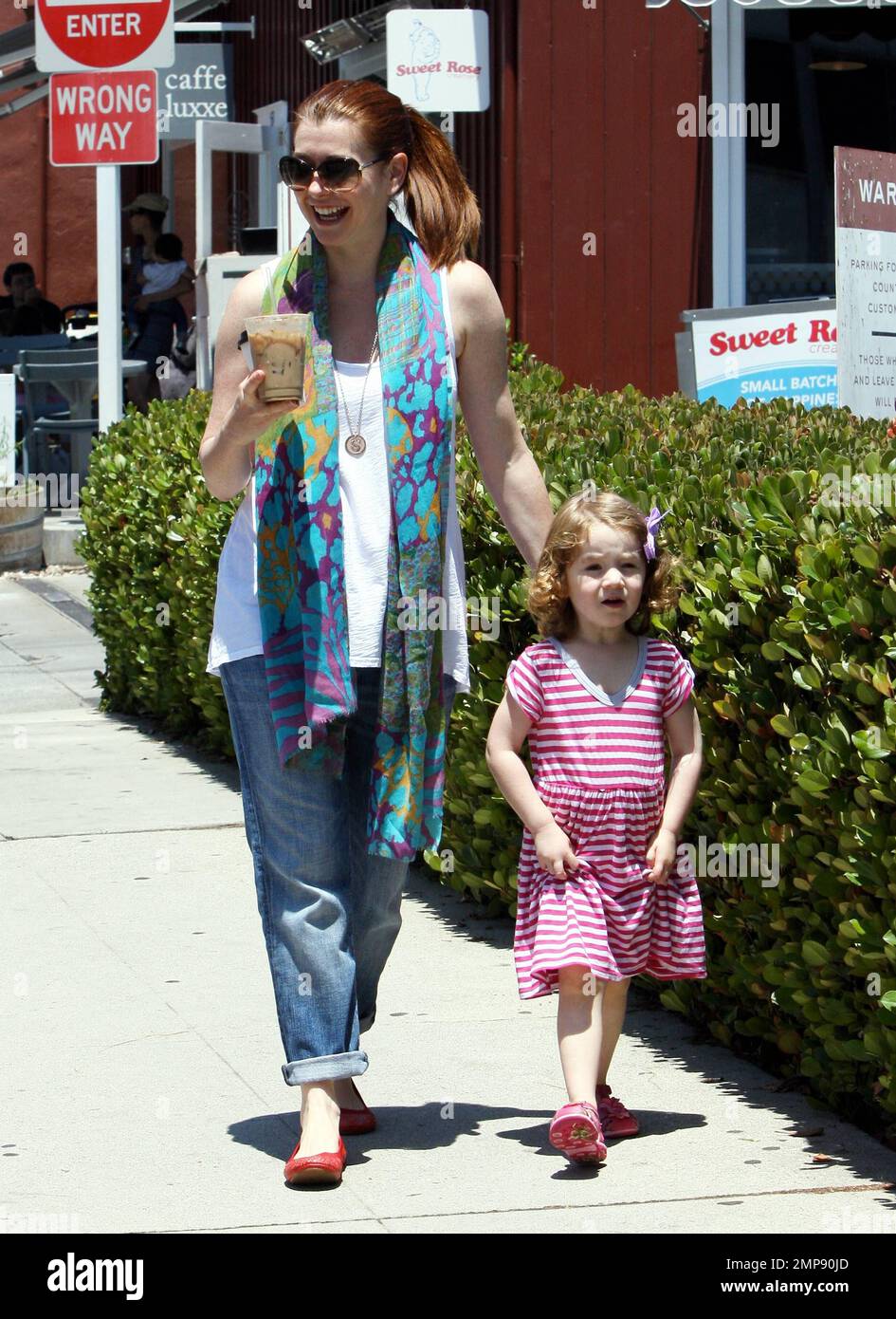 Die Schauspielerin Alyson Hannigan und ihre Familie verbringen den Tag gemeinsam im Brentwood Country Mart. Alyson fütterte ein Lama und spazierte später mit ihrem Mann Alexis Denisof, der die neue Tochter Keeva Jane Denisof in einem Kinderwagen schubste, und Tochter Satyana Marie Denisof, die sehr verspielt durch das Gras zu laufen schien. Los Angeles, Kalifornien. 15. Juli 2012 . Stockfoto