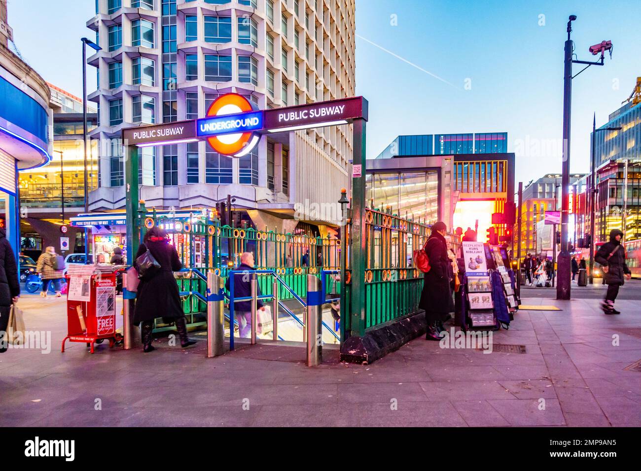 Ein Eingang mit Treppen hinunter zur Londoner U-Bahnstation Tottenham Court Road beleuchtet sich, wenn es abends dunkel wird. Stockfoto