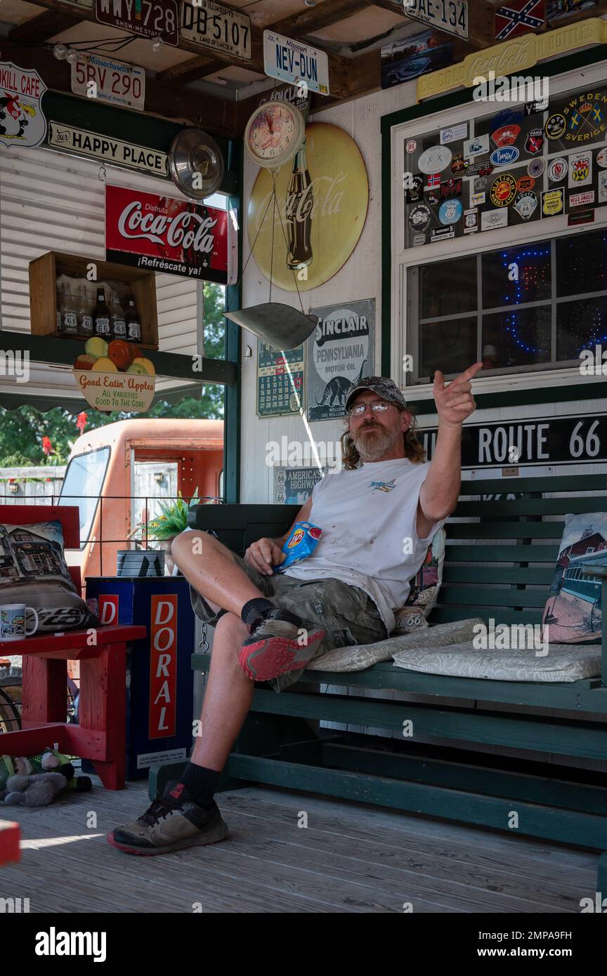 Eine vertikale Aufnahme des Besitzers der Gary's Gay Parita Sinclair Tankstelle, die auf der Bank sitzt Stockfoto Eine vertikale Aufnahme des Besitzers der Gary's Gay Parita Sinclair Tankstelle, die auf der Bank sitzt Stockfoto