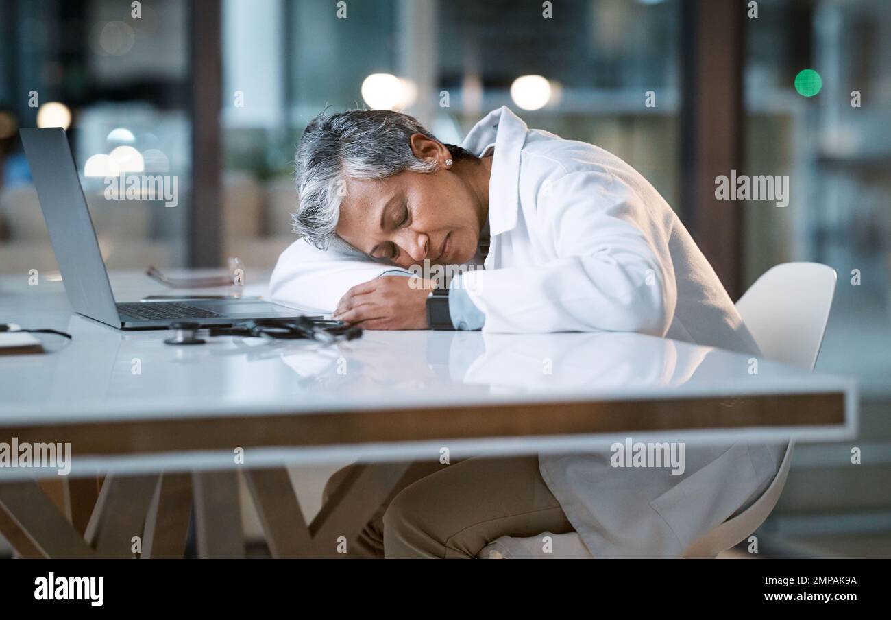 Frau Doktor schläft am Schreibtisch in der Überstunden-Arztpraxis, Spätkrankenhaus und Burnout. Stress, Nacht- und Pflegekräfte schlafen am Tisch mit Müdigkeit Stockfoto