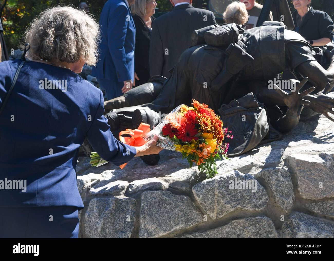 Der Künstler Abbe Godwin legt Blumen an die Basis des Corpsmen Memorial. Godwin ist die Künstlerin hinter der Statue, die sie „CorpsmanUp“ betitelte. Die Gedenkstätte wurde am 12. Oktober 2022 der Öffentlichkeit offiziell enthüllt. Stockfoto