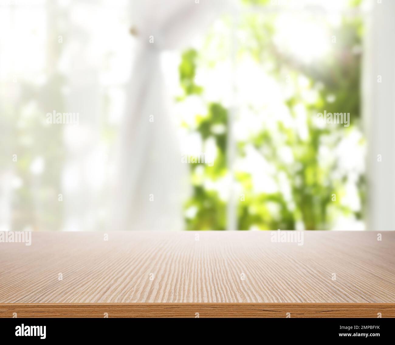 Leerer Holztisch vor dem Fenster. Sonniger Morgen Stockfoto