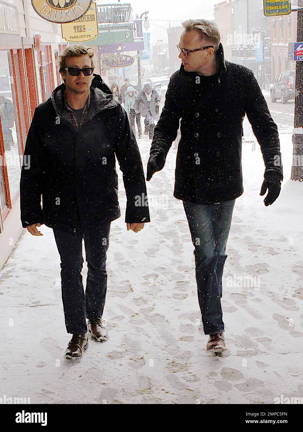 Simon Baker und Paul Bettany unterhalten sich während eines Schneesturms auf der Main Street beim Sundance Film Festival. Park City, UT. 01/25/2011. Stockfoto